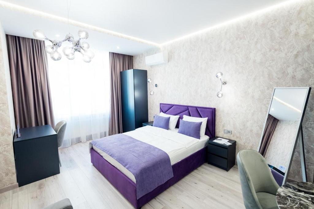 a hotel room with a purple bed and a chair at barasport city apartments in Kyiv