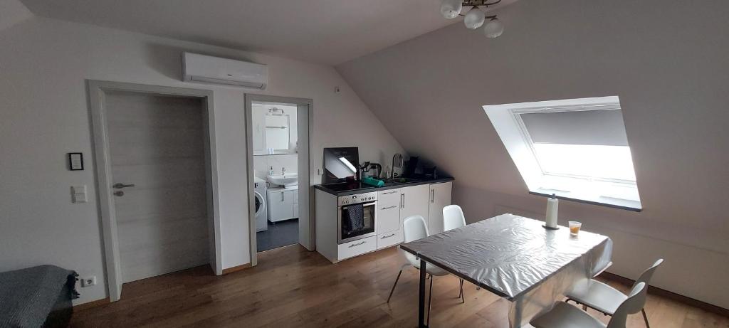 a dining room with a table and a kitchen at Messe Apartment BIN in Hildesheim
