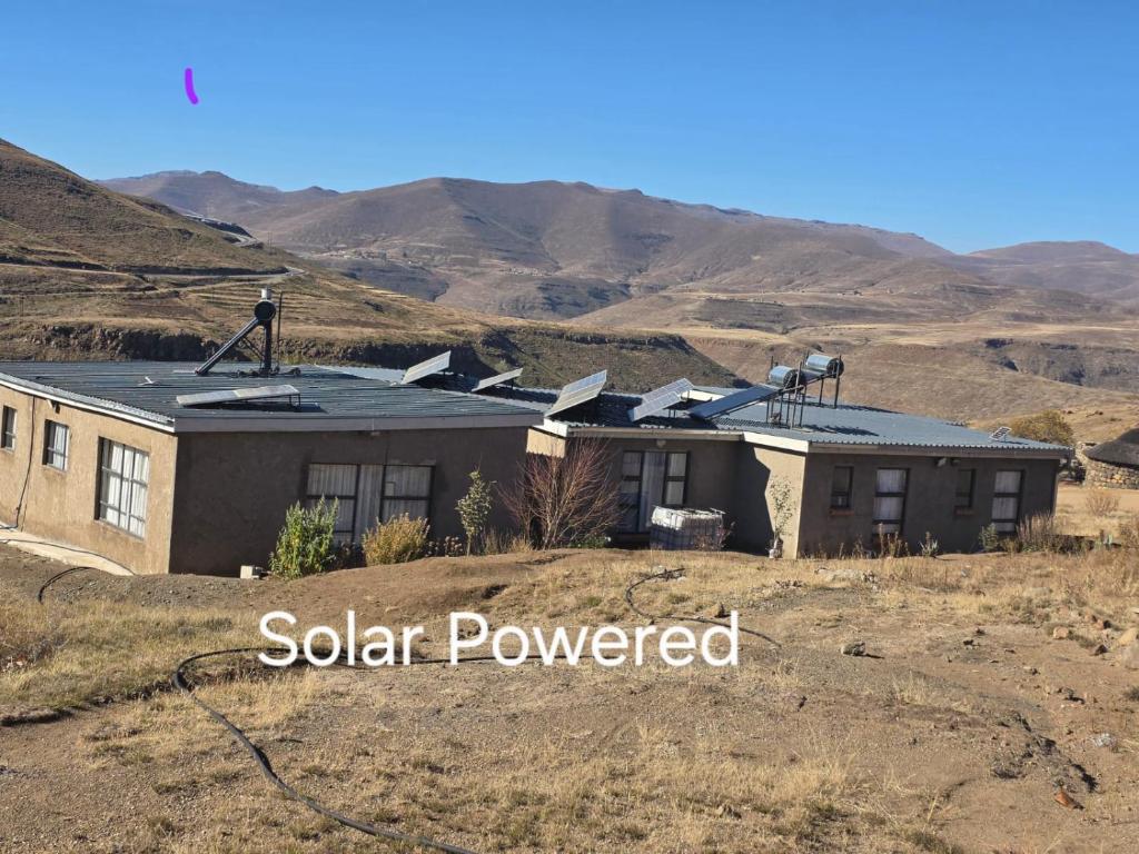 a house in a field with mountains in the background at Lillies House in Mokoeng