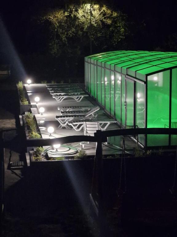 a building with a green roof at night at Domki Marcus in Rowy
