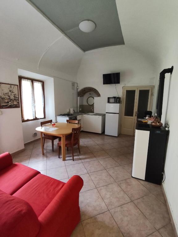 a living room with a red couch and a table at Appartamento in Corte Storica in Alzano Lombardo