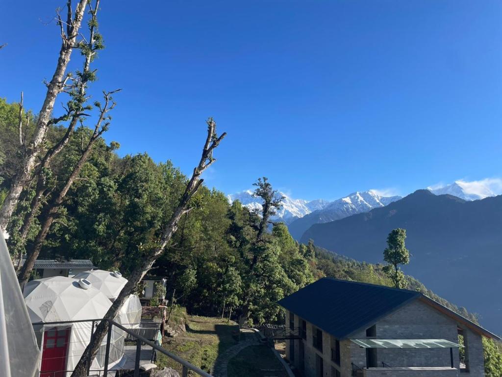 a view of a house with mountains in the background at Devshal Eco-Stays in Gupta Kāshi