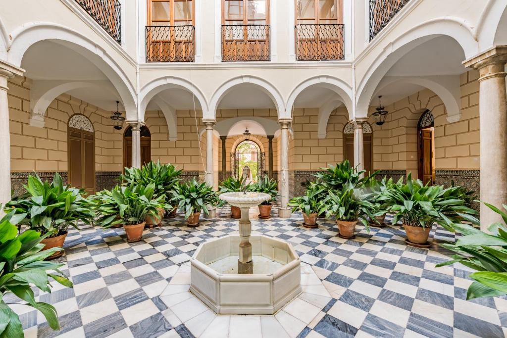 a courtyard with a fountain in a building with plants at Apartamento Garcia Lorca II in Granada