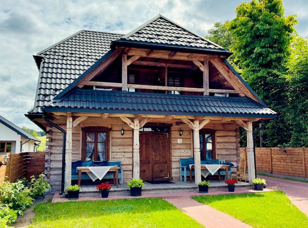 a wooden cabin with a blue roof at Agroturystyka Na Górze - Obrocz 116A in Obrocz