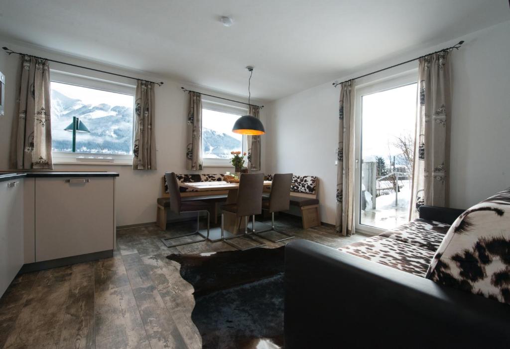 a kitchen and dining room with a table and windows at Appartement Christine in Zell am See