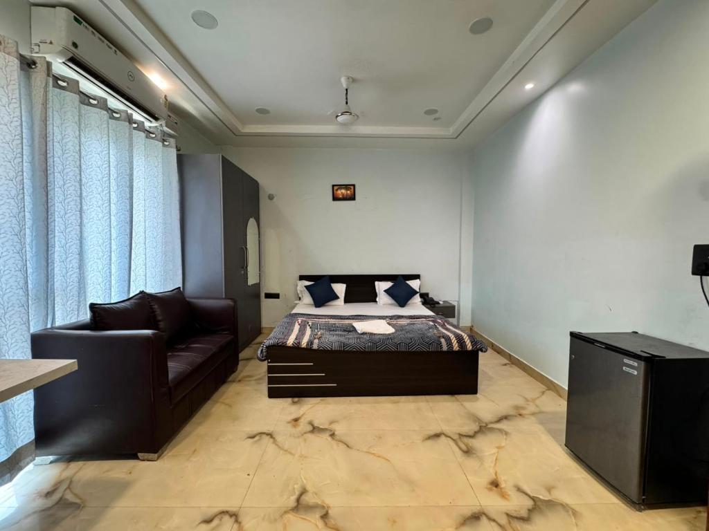 a bedroom with a bed and a couch at Atmosphere Hotel & Restaurant in Alīgarh