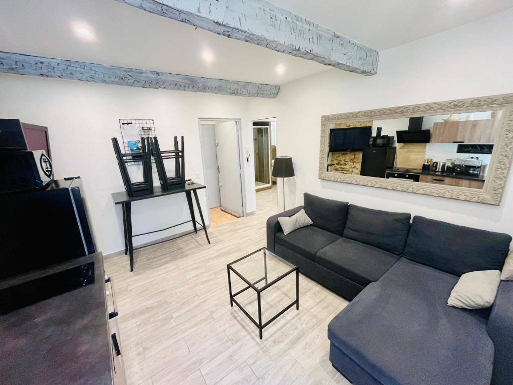 a living room with a couch and a tv at Appartement T2 centre village in Cucuron