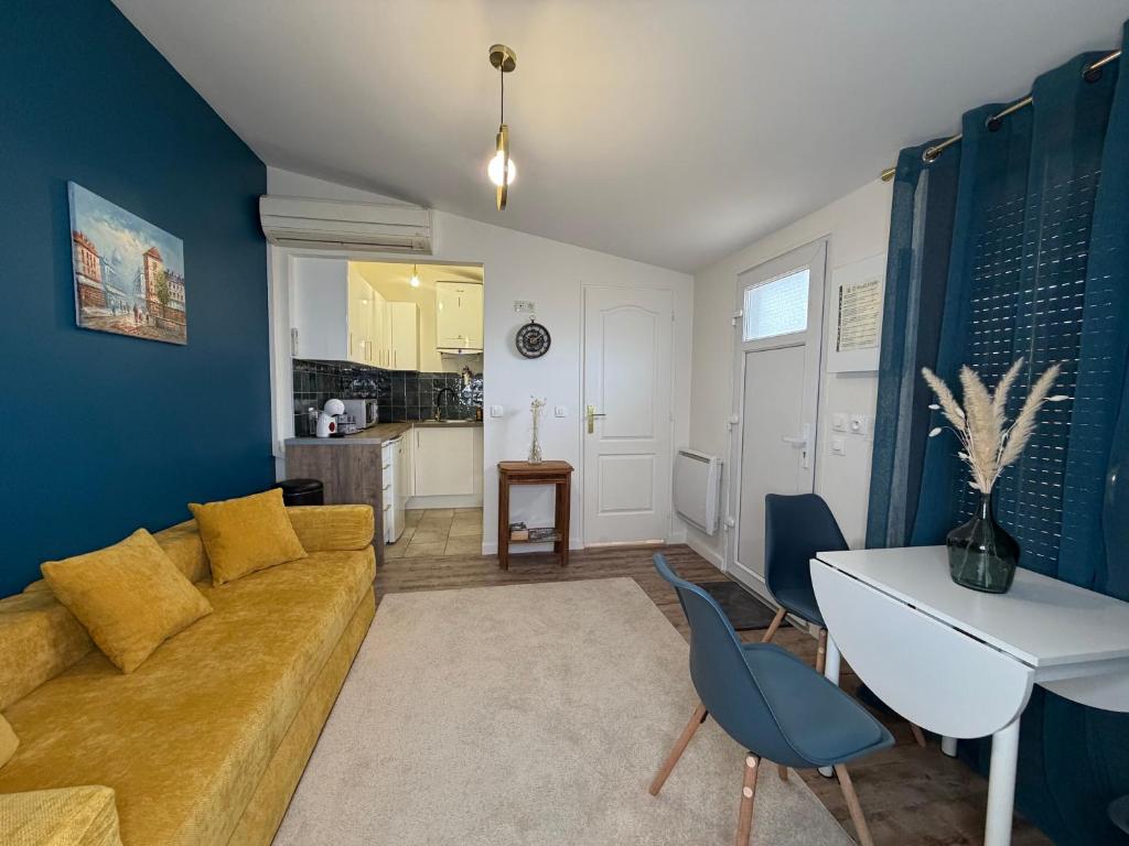 a living room with a couch and a table at Studio moderne climatisé - Parking gratuit - Paris & Disney in Ormesson-sur-Marne