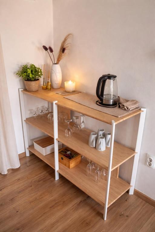 a shelf with wine glasses and a candle at Apartman Sidonija in Križevci