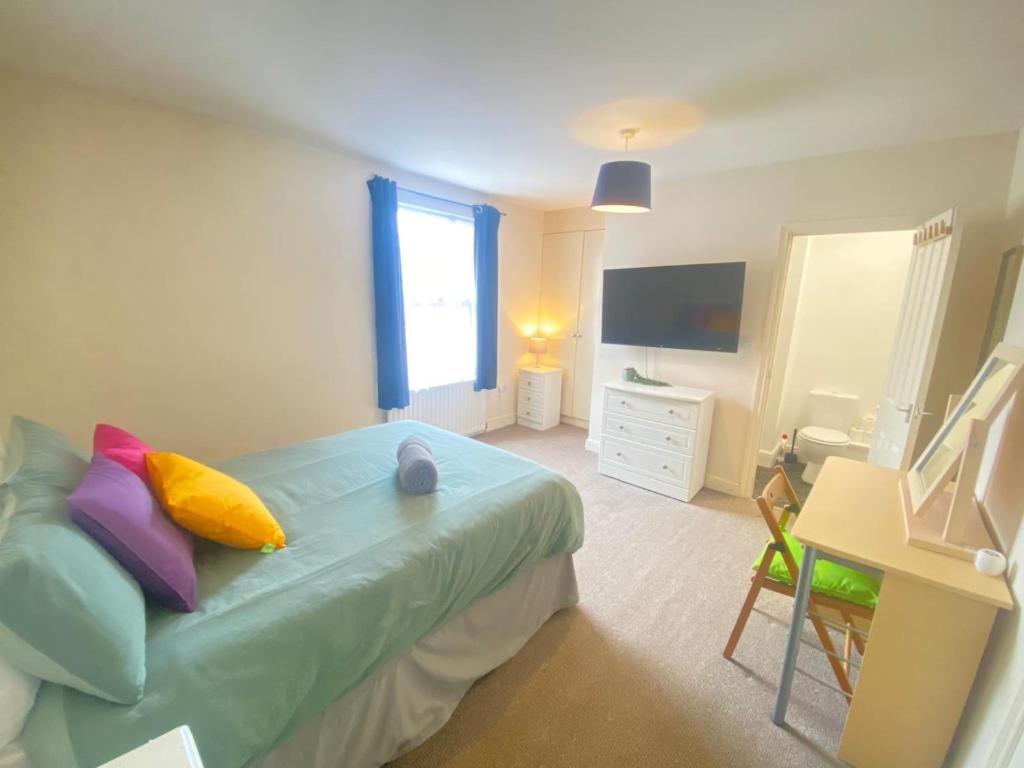 a bedroom with a bed and a desk and a television at 4-5 Bedroom House For Corporate Stays in Kettering in Kettering