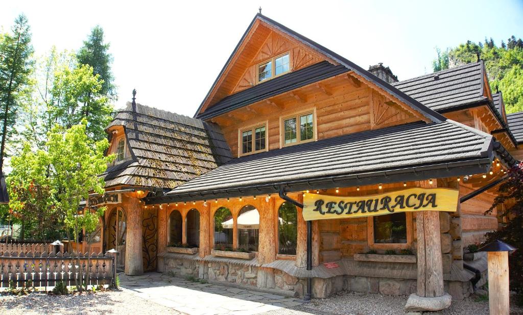a log cabin with a sign in front of it at Apartamenty w Dolinie Kościeliskiej in Kościelisko