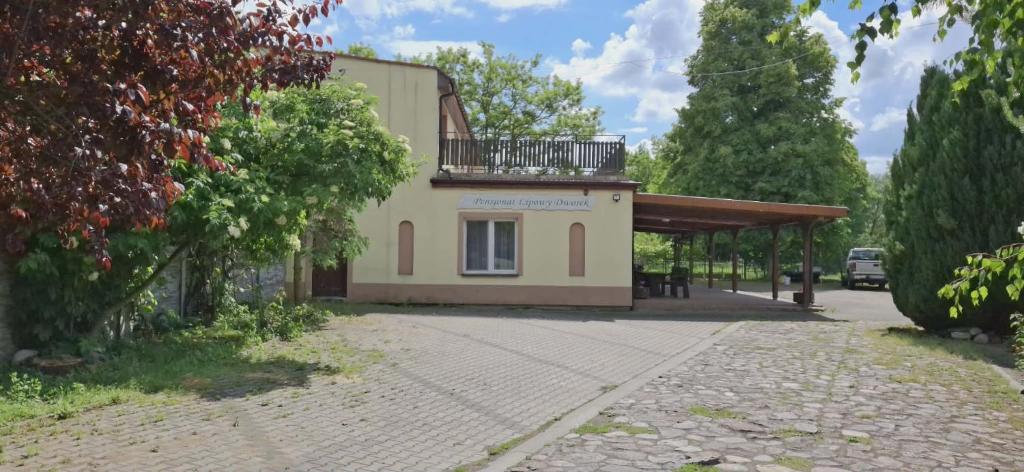 a building with a balcony on top of it at Lipowy Dworek Pensjonat in Staroguby
