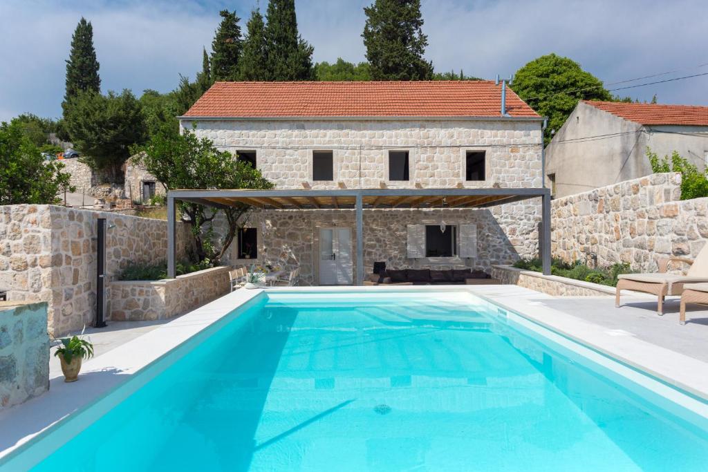 ein großer Pool vor einem Steinhaus in der Unterkunft Villa Ostrinus VH VIII in Orasac