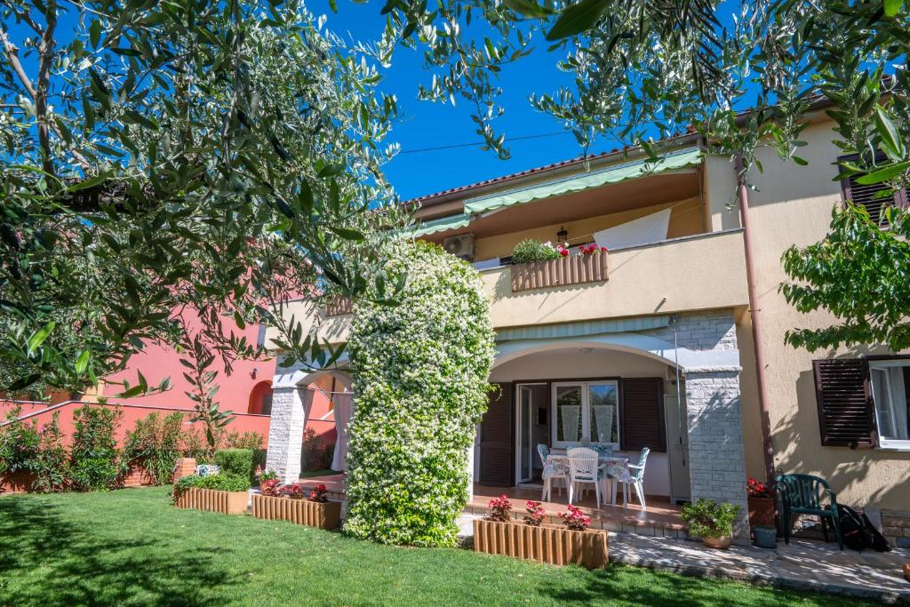 a villa with a garden and a house at Apartments Mirella in Novigrad Istria
