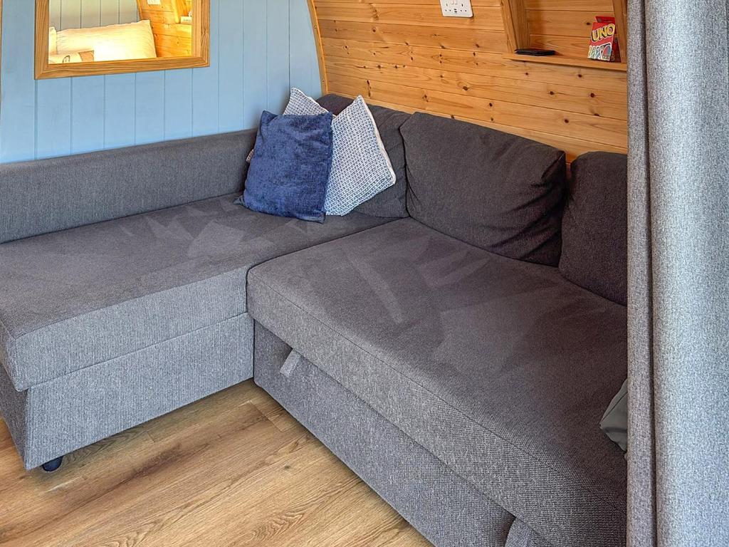 a gray couch with two pillows on it in a room at The Appleton - Ukc9283 in Brompton