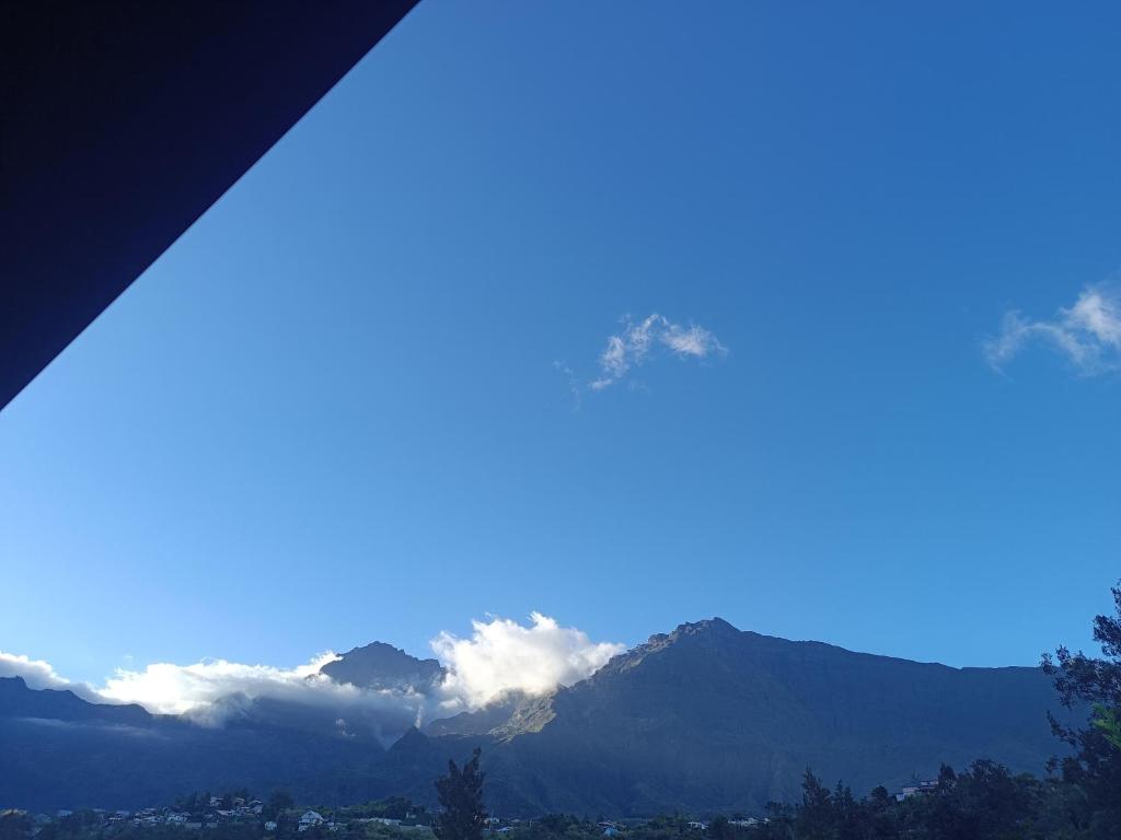 a view of a mountain with clouds in the sky at La grande découverte 2 in Cilaos