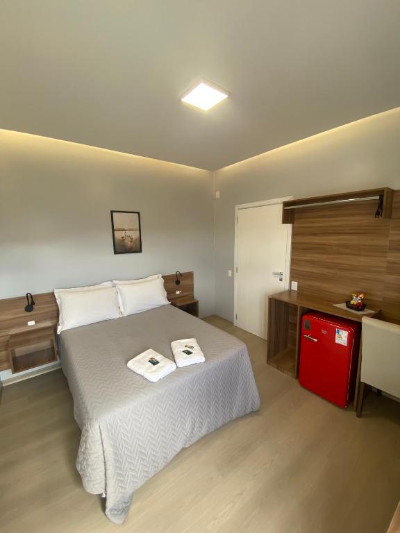a bedroom with a bed with two towels on it at Hotel Westphal in Pelotas
