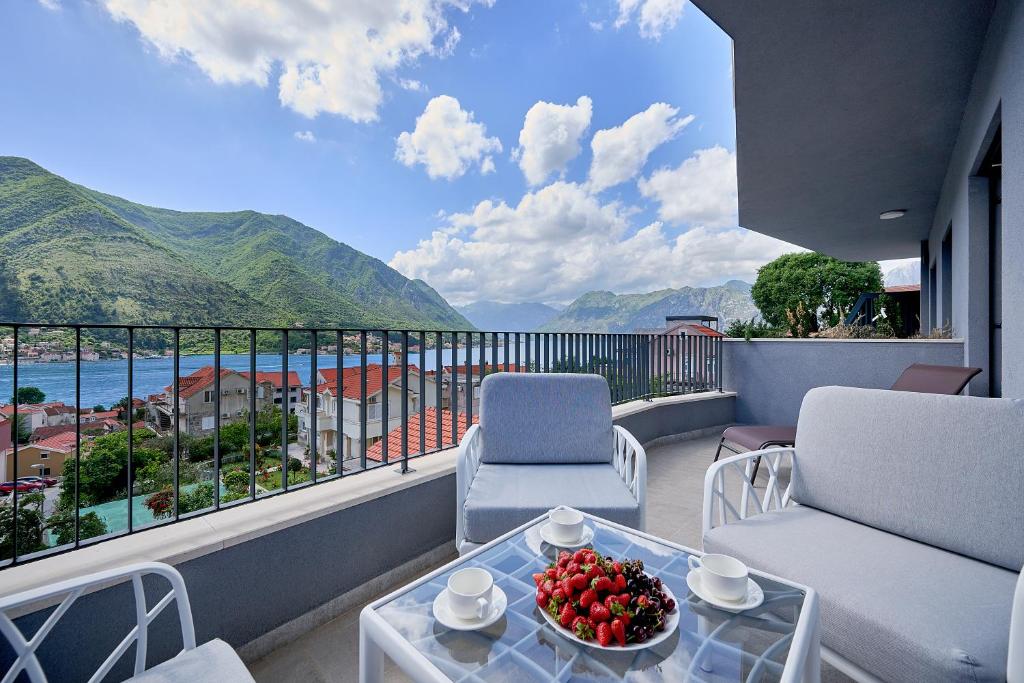 a balcony with a table and chairs and a view at Boka Bay by MN Property in Dobrota