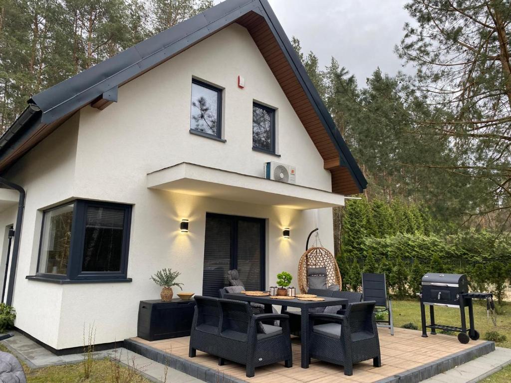 a house with a table and chairs in front of it at Leśna Przystań Kaszuby in JeleÅ„ska Huta