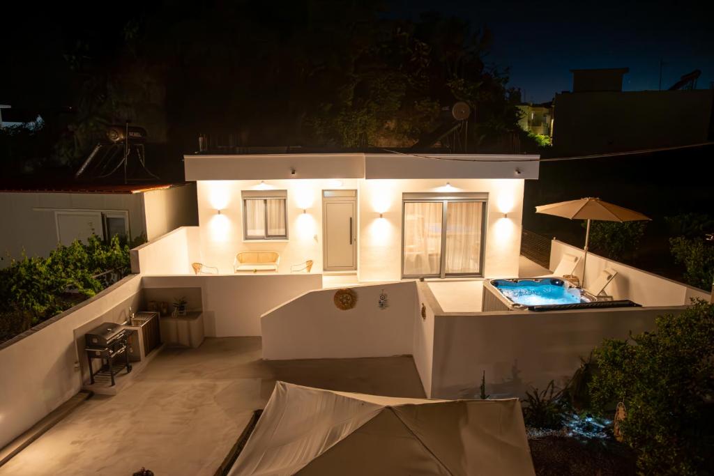 a white house with a swimming pool at night at CASA Terraya in Afantou