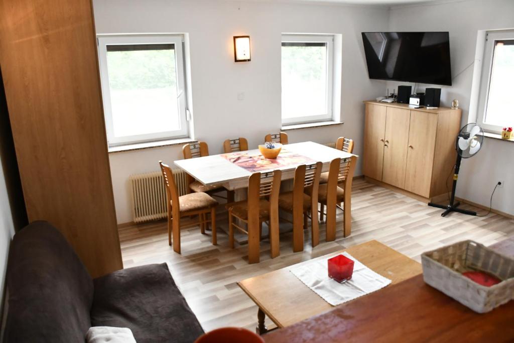 a living room with a table and chairs and a television at Počitniška hiša REMA in Lendava