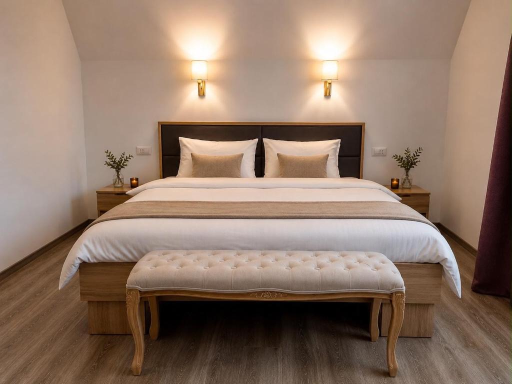 a bedroom with a large bed with a bench in it at Pensiunea Mirage in Iaşi
