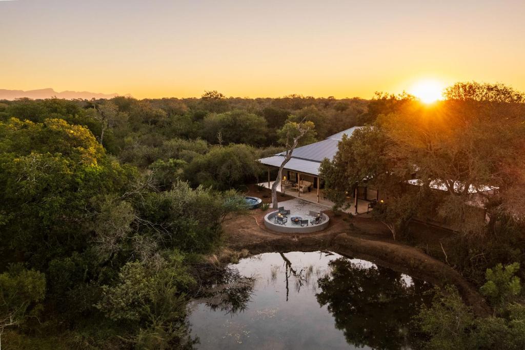 an aerial view of a house with a pond at Nomads Den Safari Villas - Heated Pools and Riverbed views in Hoedspruit