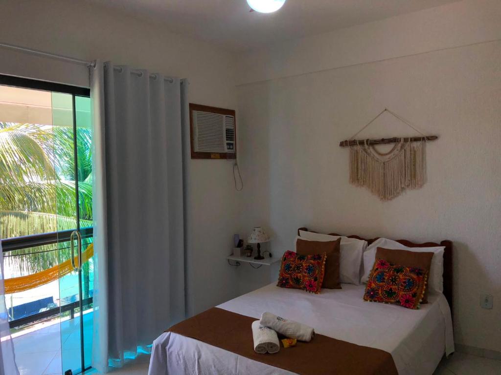 a bedroom with a bed and a large window at Upwind in Araruama