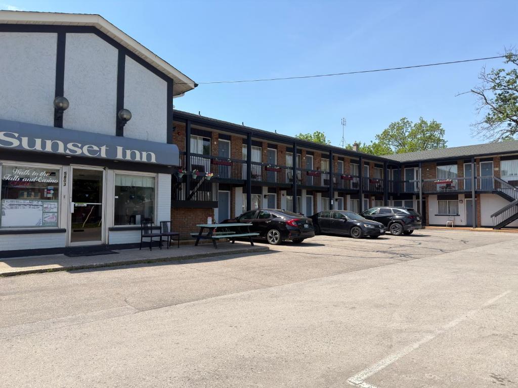 a building with cars parked in a parking lot at Sunset Inn in Niagara Falls