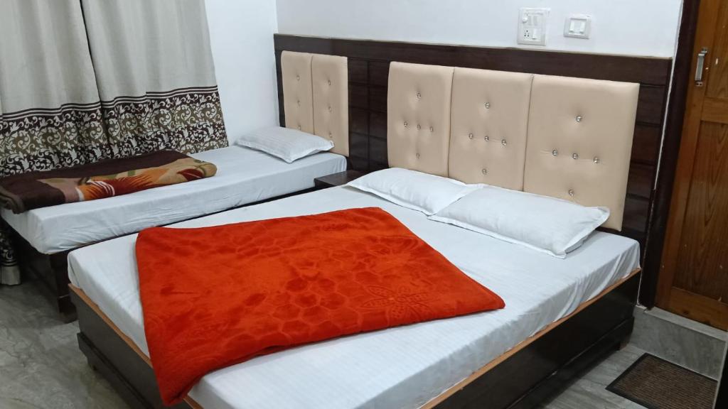 two beds in a room with a red blanket on them at Kunjapuri Homestay in Uttarkāshi