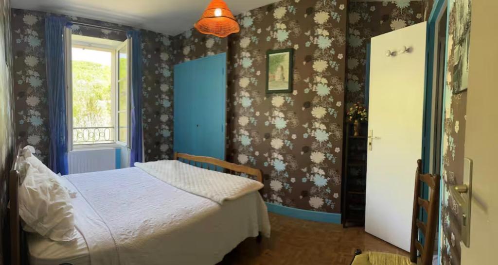 a bedroom with a bed and a window at Chambres du Causse in Saint-Cernin-de-Larche