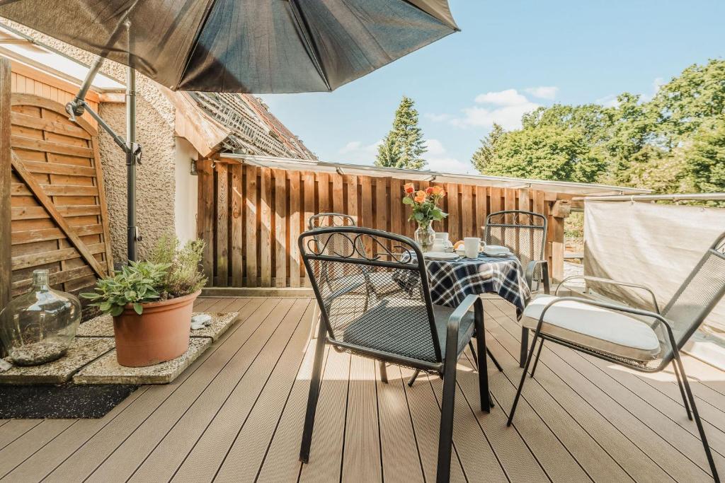a table and chairs on a deck with an umbrella at Haus Teltow in Teltow