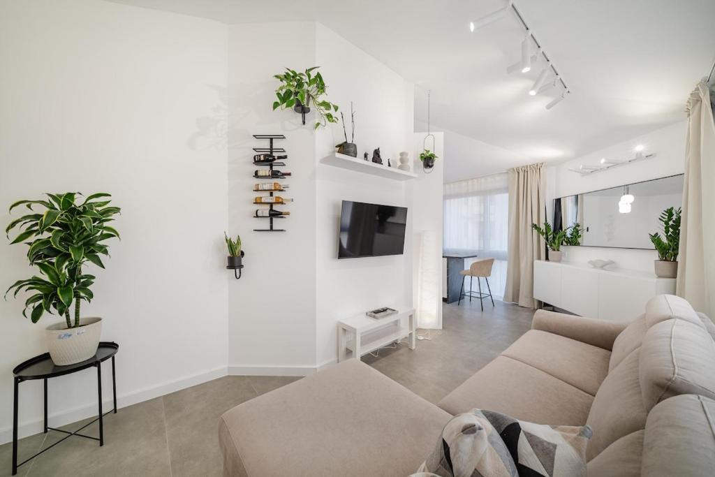a white living room with a couch and a table at Sanseveria in Španjola