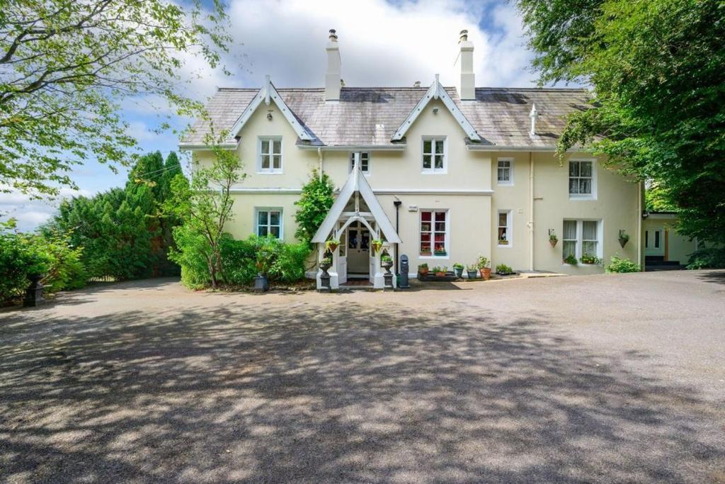 a large white house with a large driveway at Robin Hill Heritage Guest House in Cobh