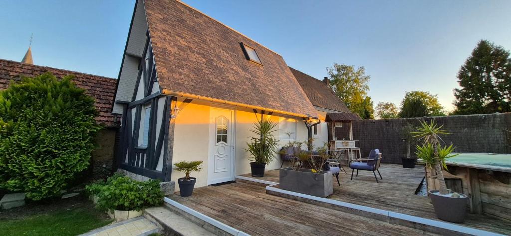 a house with a wooden deck with a swimming pool at La maisonnette in Forêt-la-Folie