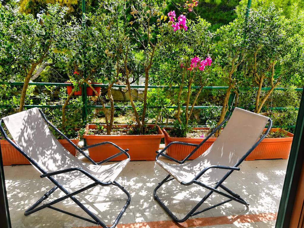 two chairs sitting on a patio with flowering plants at Il Giardino su Lido Burrone in Favignana