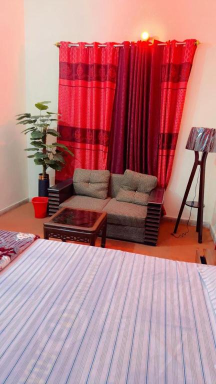 a living room with a couch and red curtains at Prime Stay in Multan