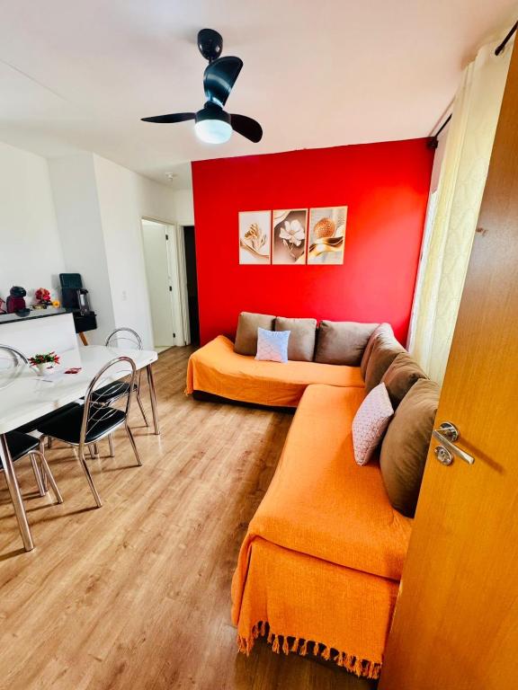a living room with a couch and a red wall at Cavalheris House - Rota das Vinícolas in Espirito Santo Do Pinhal