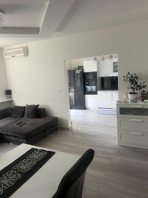 a living room with a bed and a kitchen at Slnečný byt pri lesoparku in Prievidza