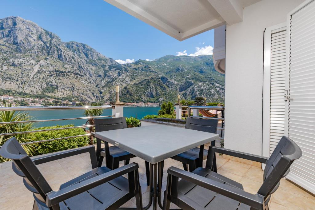 a table and chairs on a balcony with a view of the water at Kotor Muo F1 in Muo