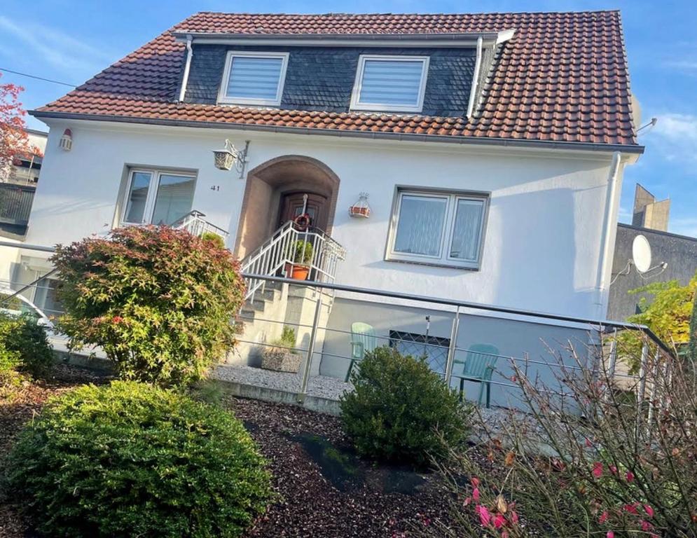 a white house with a balcony in front of it at Pension Hoffmann Remscheid in Remscheid