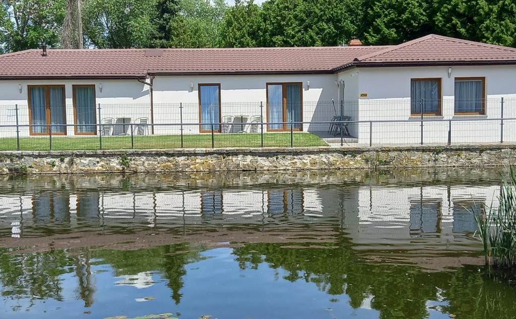 a building next to a body of water at Apartamenty przy Starym Basenie in Sobótka