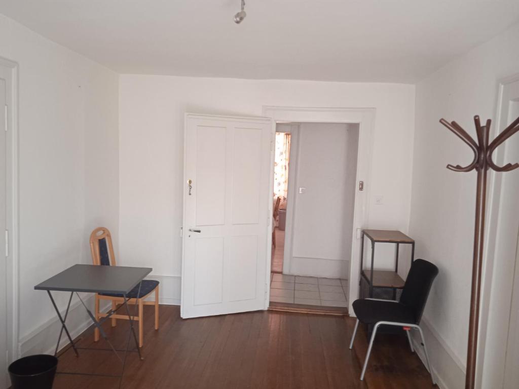 a white room with a table and a chair at Chambre B 1 étage avec balcon in Biel