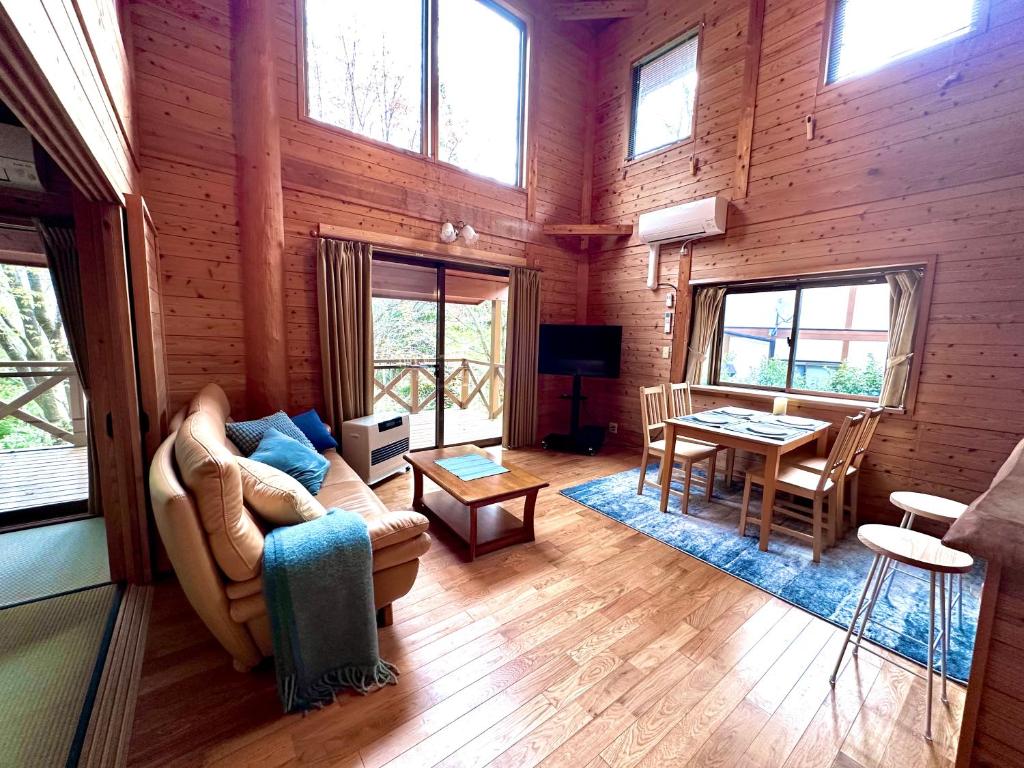 a living room with a couch and a table at Lodge Kurokawa 2 Forest in Minamioguni