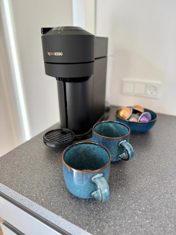 two cups on a counter with a coffee maker at Feriebyens Spahuse in Rødvig