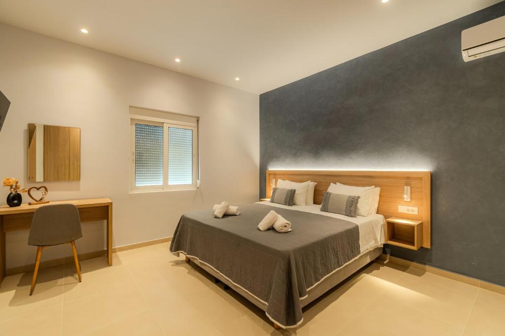 a bedroom with a bed and a desk and a chair at Aspasia House in Platanias