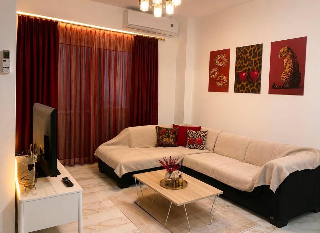 a living room with a couch and a tv at Cherry Blossom Apartment in Xanthi
