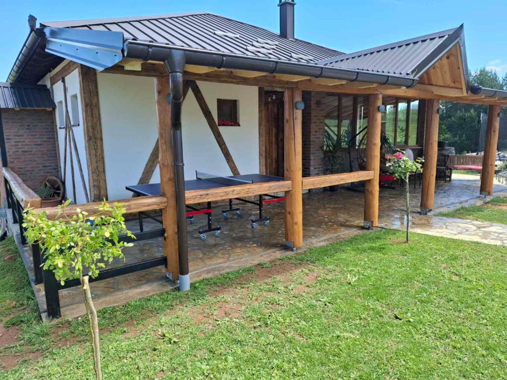 a wooden pavilion with a picnic table in a yard at Seosko domaćinstvo Kastratović in Berane