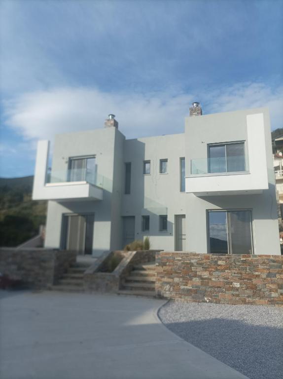 a rendering of a white house with a stone wall at Almira Suites by the sea 3 in Áyios Dhimítrios