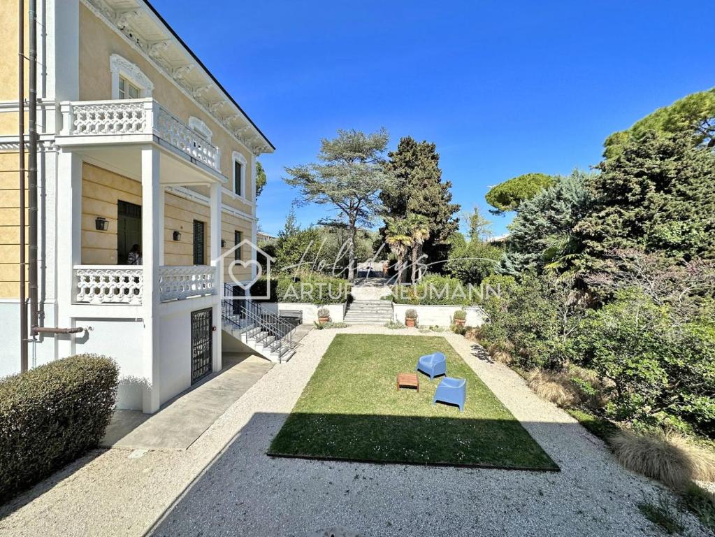 a garden in the front of a house at 207 - VILLA FERNANDA - Bilocale di charme al piano terra immerso nel verde, in centro e a pochi passi dal mare SPIAGGIA AL WHITE BEACH CLUB IN OMAGGIO dal lun al ven dal 24-08 in Sirolo